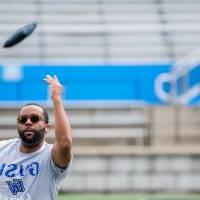 DaMar Boyd underhand tossing a cornhole bag into the air